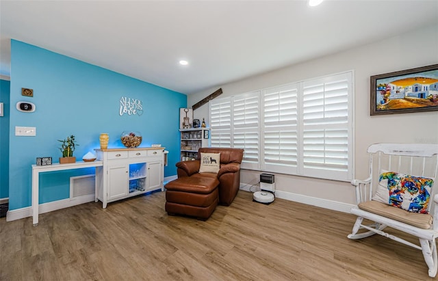 living area with wood finished floors, recessed lighting, visible vents, and baseboards
