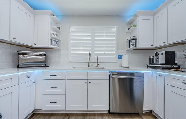 kitchen featuring a sink, open shelves, white cabinetry, light countertops, and stainless steel dishwasher