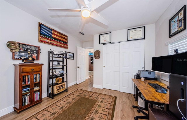 office area featuring baseboards, visible vents, a ceiling fan, and light wood finished floors