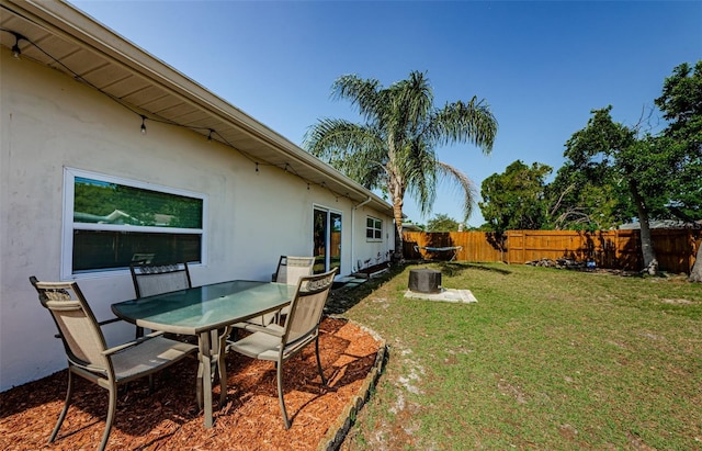 view of yard featuring outdoor dining area and a fenced backyard
