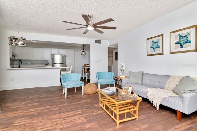 1400 Pine Glen Ln Unit B2, Tarpon Springs, FL 34688 - living area with wood finished floors, a textured ceiling, a ceiling fan, and baseboards