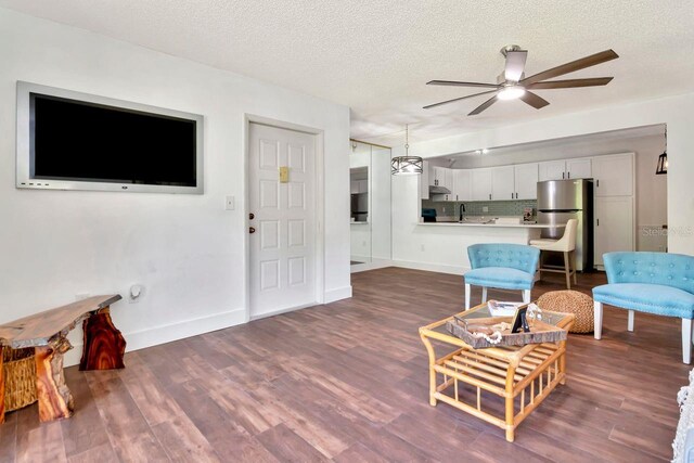 1400 Pine Glen Ln Unit B2, Tarpon Springs, FL 34688 - living room featuring a ceiling fan, a textured ceiling, and dark wood-type flooring