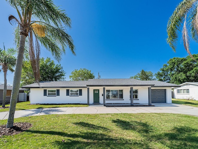 ranch-style home with a front lawn, stucco siding, an attached garage, concrete driveway, and a porch