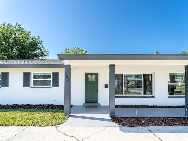 ranch-style home featuring covered porch and stucco siding
