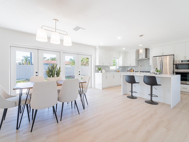 dining room with recessed lighting, visible vents, light wood finished floors, and french doors