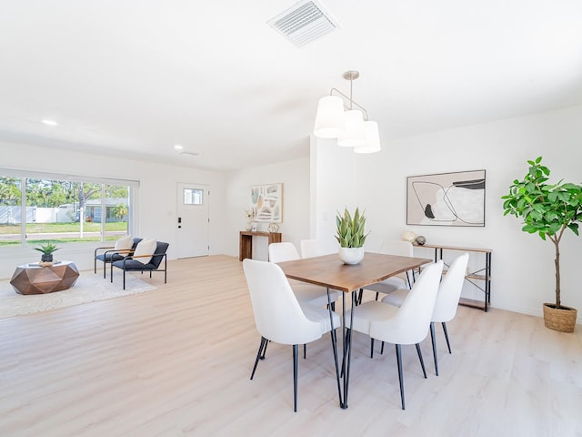dining room featuring light wood finished floors, baseboards, visible vents, and recessed lighting
