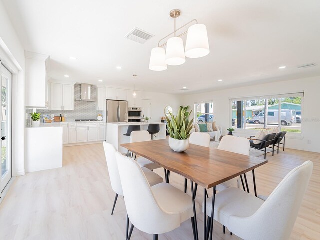 dining space featuring light wood finished floors, visible vents, and recessed lighting
