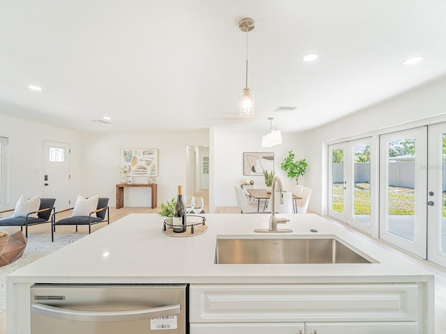 kitchen featuring light countertops, dishwasher, and a sink