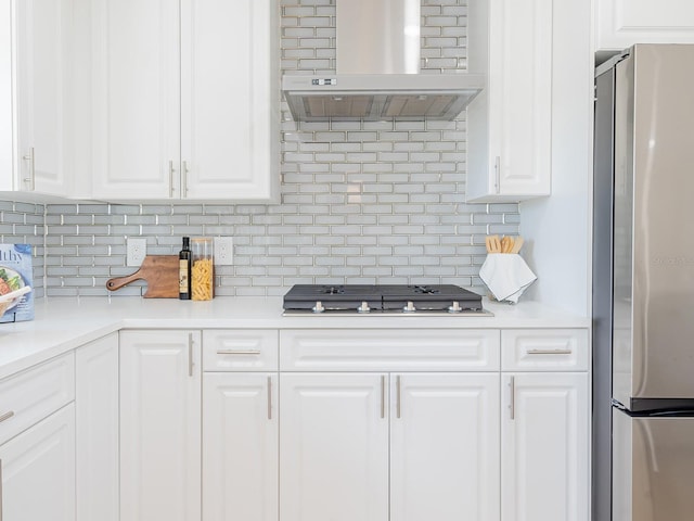 kitchen with ventilation hood, stainless steel appliances, light countertops, decorative backsplash, and white cabinetry
