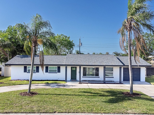 ranch-style house with an attached garage, stucco siding, a front yard, and concrete driveway