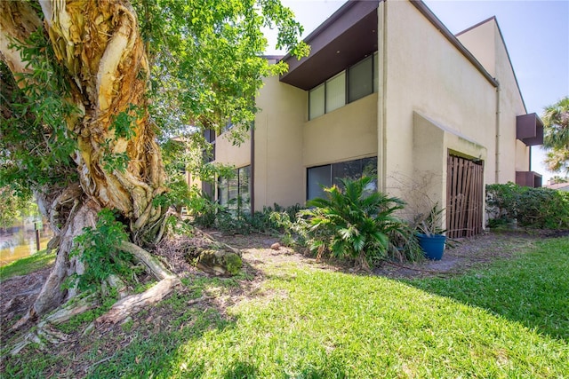 782 Village Lake Ter N Unit 102, Saint Petersburg, FL 33716 - view of property exterior featuring stucco siding and a lawn
