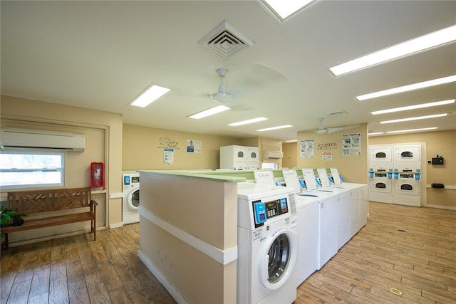 782 Village Lake Ter N Unit 102, Saint Petersburg, FL 33716 - communal laundry room featuring stacked washer / drying machine, an AC wall unit, separate washer and dryer, light wood-style flooring, and ceiling fan