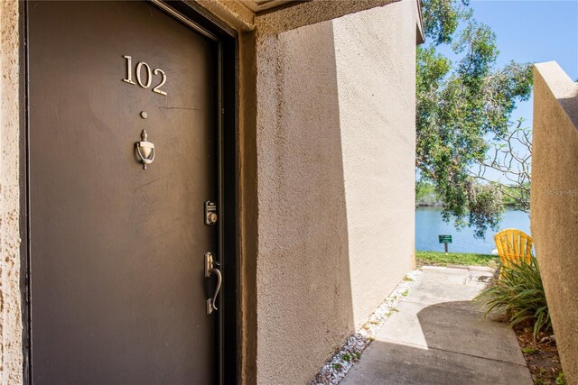 782 Village Lake Ter N Unit 102, Saint Petersburg, FL 33716 - property entrance with stucco siding and a water view