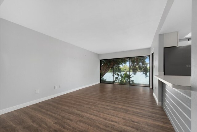 782 Village Lake Ter N Unit 102, Saint Petersburg, FL 33716 - unfurnished living room with dark wood-style floors and baseboards