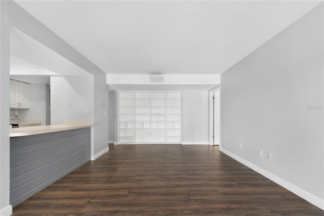 782 Village Lake Ter N Unit 102, Saint Petersburg, FL 33716 - unfurnished living room with baseboards, dark wood-style floors, and built in shelves