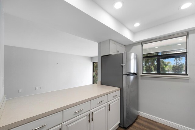 782 Village Lake Ter N Unit 102, Saint Petersburg, FL 33716 - kitchen featuring freestanding refrigerator, baseboards, white cabinetry, dark wood finished floors, and light countertops