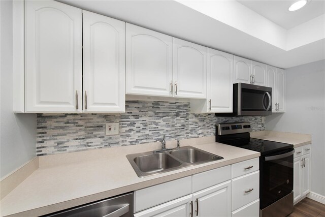 782 Village Lake Ter N Unit 102, Saint Petersburg, FL 33716 - kitchen with appliances with stainless steel finishes, a sink, white cabinets, and backsplash