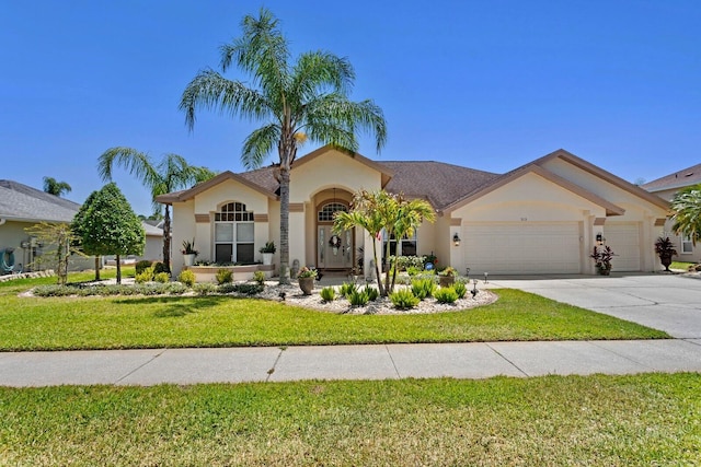 mediterranean / spanish home with a front lawn, driveway, a garage, and stucco siding
