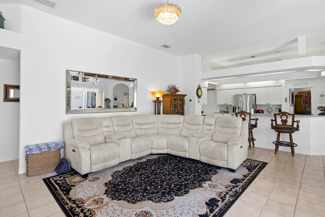 living area featuring light tile patterned flooring, visible vents, and baseboards