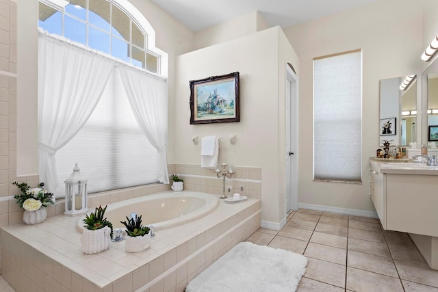 full bathroom featuring a garden tub, vanity, tile patterned flooring, and baseboards