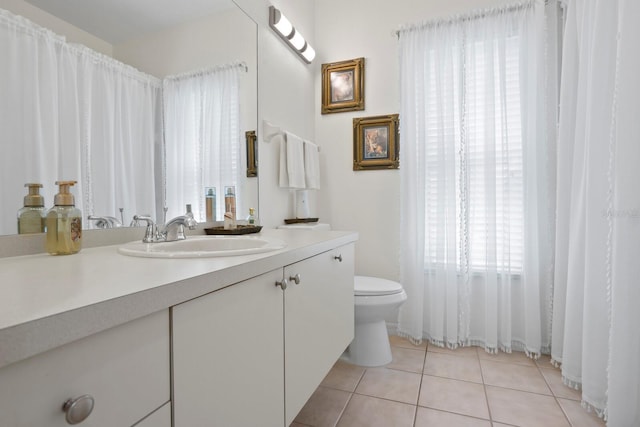 full bath featuring toilet, vanity, and tile patterned floors