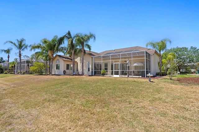 back of property with a lanai and a lawn