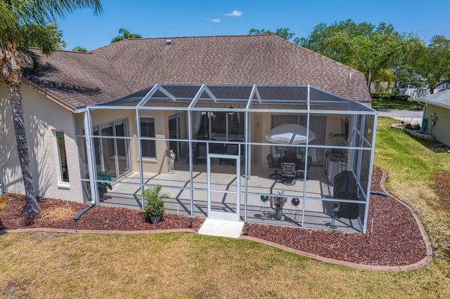 rear view of property featuring stucco siding, a yard, and a patio area