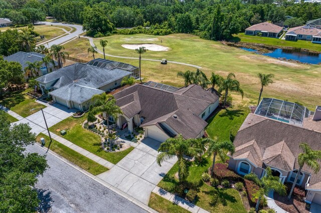 bird's eye view with golf course view, a water view, and a residential view