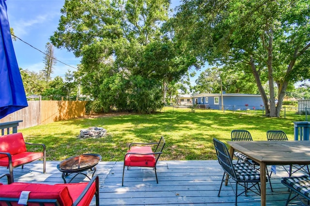 6207 Gulfport Blvd S, Gulfport, FL 33707 - deck featuring a lawn, a fenced backyard, a fire pit, and outdoor dining space