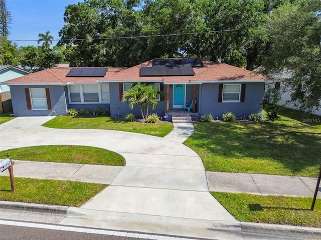 6207 Gulfport Blvd S, Gulfport, FL 33707 - ranch-style house with a front lawn, a shingled roof, curved driveway, roof mounted solar panels, and stucco siding