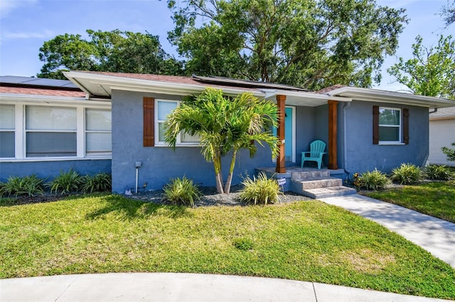 6207 Gulfport Blvd S, Gulfport, FL 33707 - single story home with solar panels, a front lawn, covered porch, and stucco siding