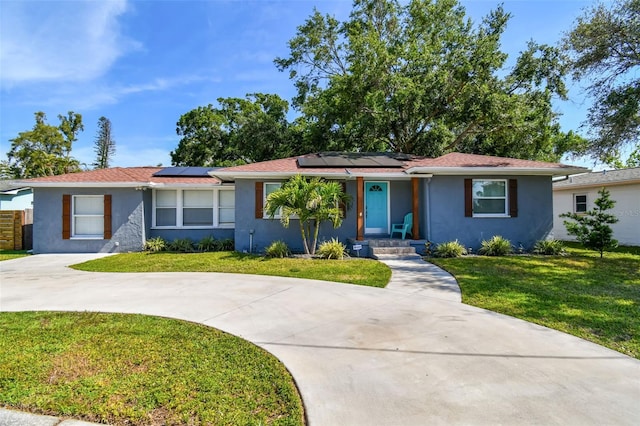 6207 Gulfport Blvd S, Gulfport, FL 33707 - single story home featuring roof mounted solar panels, a front lawn, stucco siding, and curved driveway