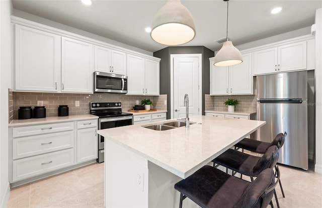 kitchen featuring decorative backsplash, a kitchen breakfast bar, stainless steel appliances, and a sink