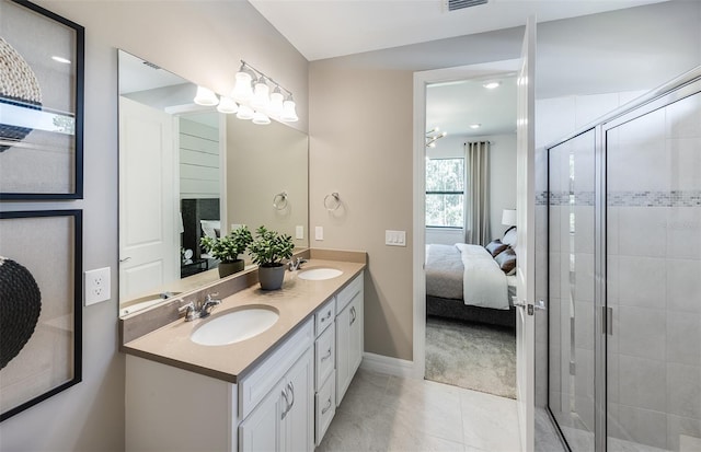 ensuite bathroom with ensuite bath, a stall shower, a sink, and baseboards