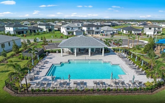pool featuring a patio area, fence, and a residential view
