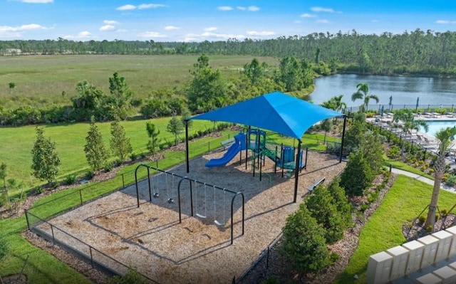 community jungle gym featuring a lawn, a view of trees, and a water view