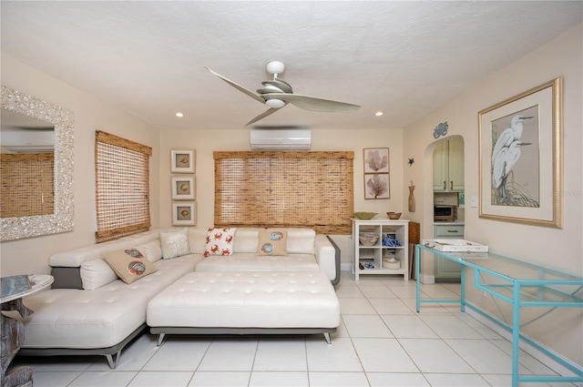 bedroom with light tile patterned floors, arched walkways, ceiling fan, and a wall mounted AC