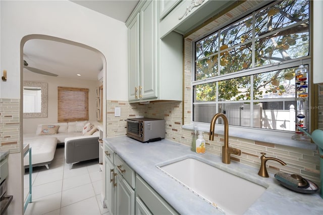 kitchen with light countertops, a toaster, a sink, and tasteful backsplash