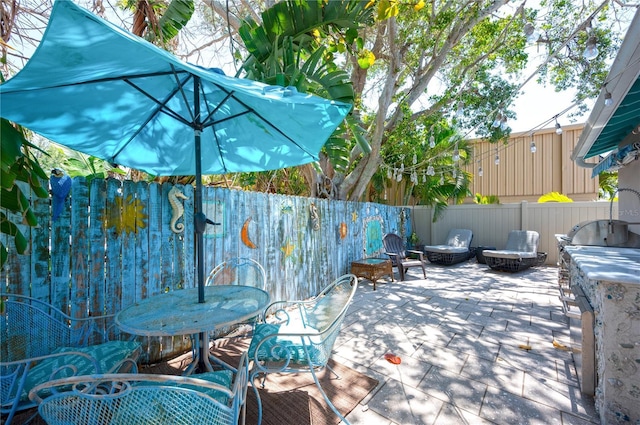 view of patio / terrace with outdoor dining area, a fenced backyard, and an outdoor fire pit