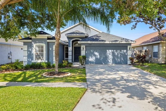 ranch-style house with a garage, stucco siding, driveway, and a front yard
