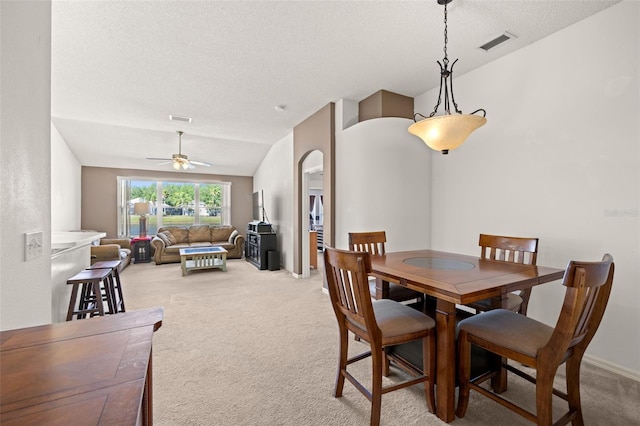 dining room featuring ceiling fan, visible vents, a textured ceiling, and light colored carpet