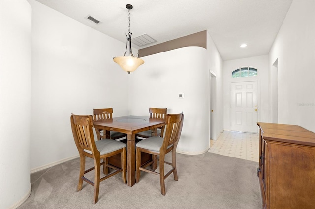dining room with baseboards, light carpet, and visible vents