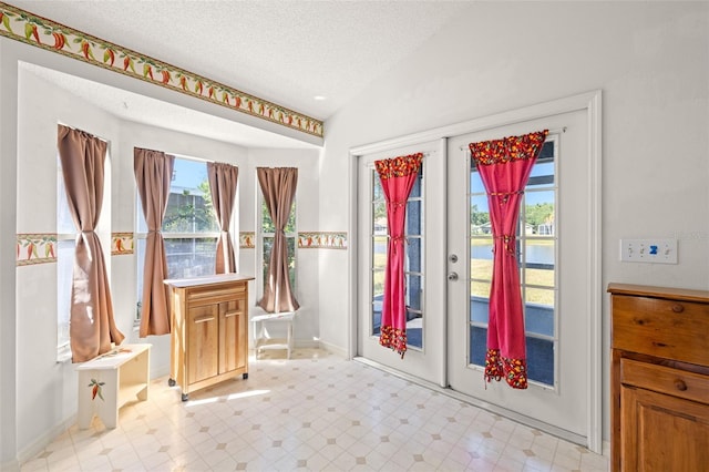 doorway featuring baseboards, a textured ceiling, a water view, french doors, and vaulted ceiling