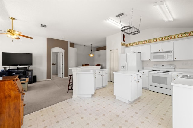 kitchen featuring white appliances, open floor plan, lofted ceiling, a kitchen island, and visible vents