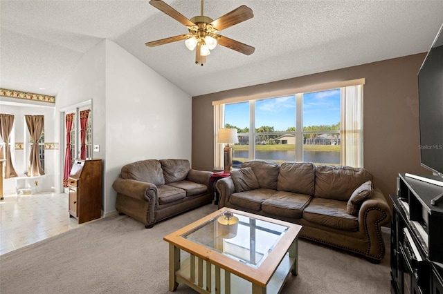 living room with ceiling fan, vaulted ceiling, a textured ceiling, and light colored carpet