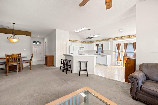 living room with ceiling fan, light carpet, baseboards, lofted ceiling, and visible vents