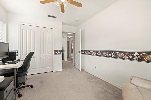 office space featuring visible vents, a ceiling fan, baseboards, and light carpet