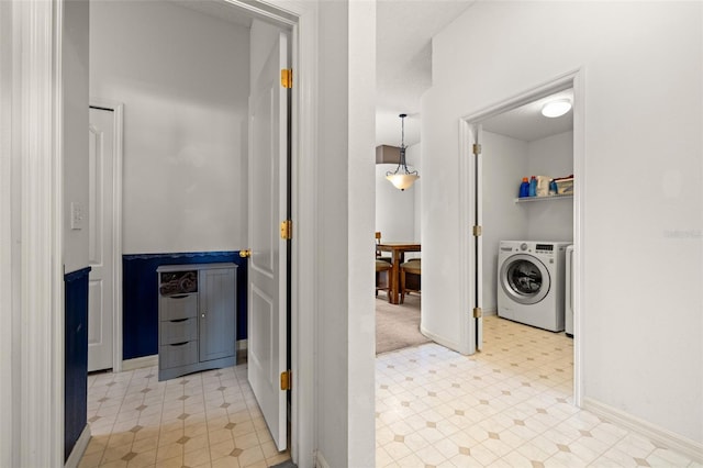 laundry area featuring light floors, baseboards, laundry area, and washing machine and clothes dryer