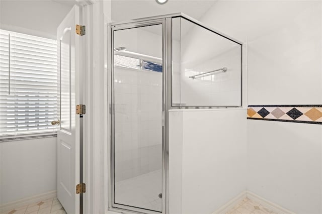 full bathroom featuring baseboards and a stall shower