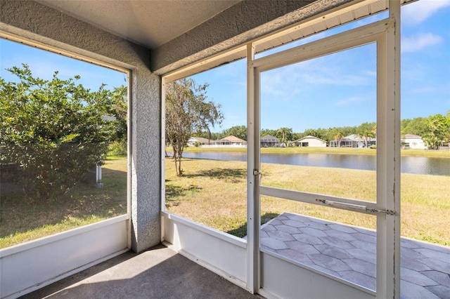 unfurnished sunroom with a water view and a residential view